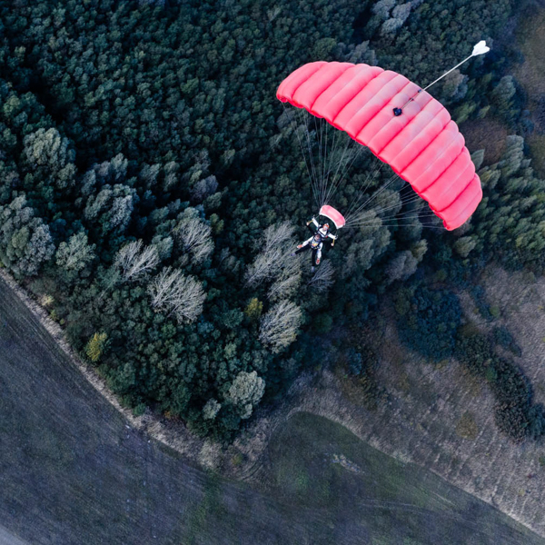 Otwarty spadochron tandemowy kilkaset metrów nad ziemią